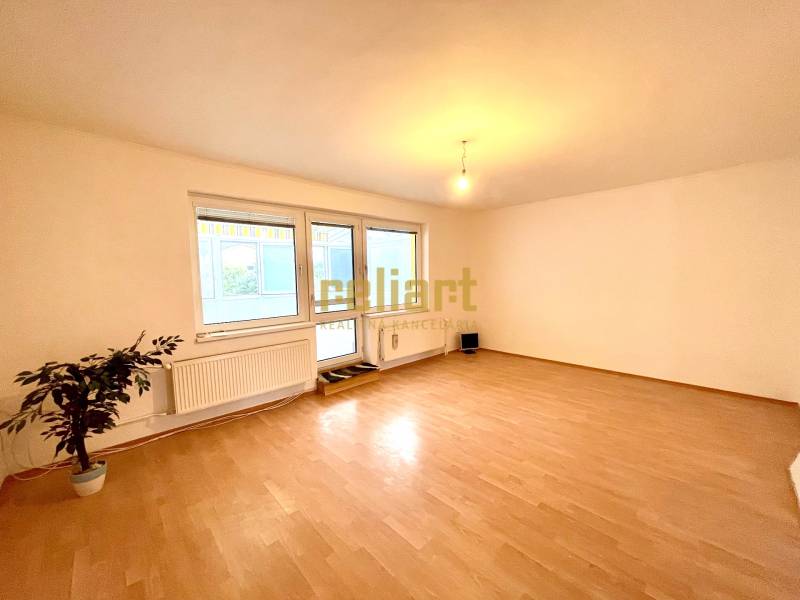A room in a family house with a wooden decor floor and large windows.