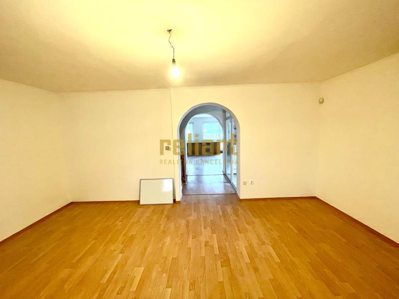 A room with an arched passage and a wooden decor floor in a family house.