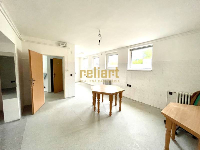 Interior of a family house with an empty room, tables, and white walls.