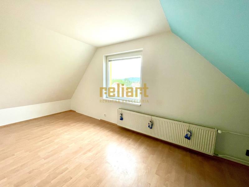 Attic room with a window and a wooden decor floor in a family house.