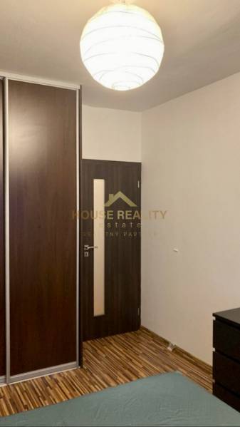 Interior with a dark built-in wardrobe, doors, and wooden decor flooring in a 3-room apartment.