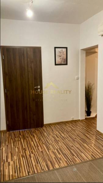 Entrance hall in a 3-room apartment with a patterned floor featuring a wooden decor and simple decoration.