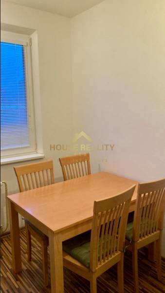 Dining table with four chairs in a 3-room apartment, floor with wooden decor.