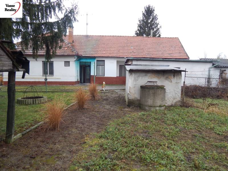 A family house in Kravany nad Dunajom with a grassy garden and a well on the property.