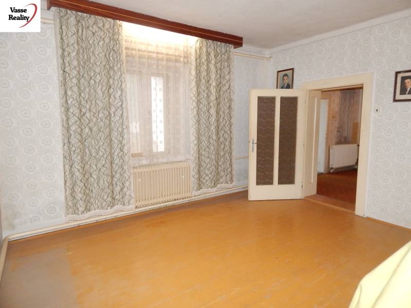 A room in a family house with a wooden decor floor and curtains.