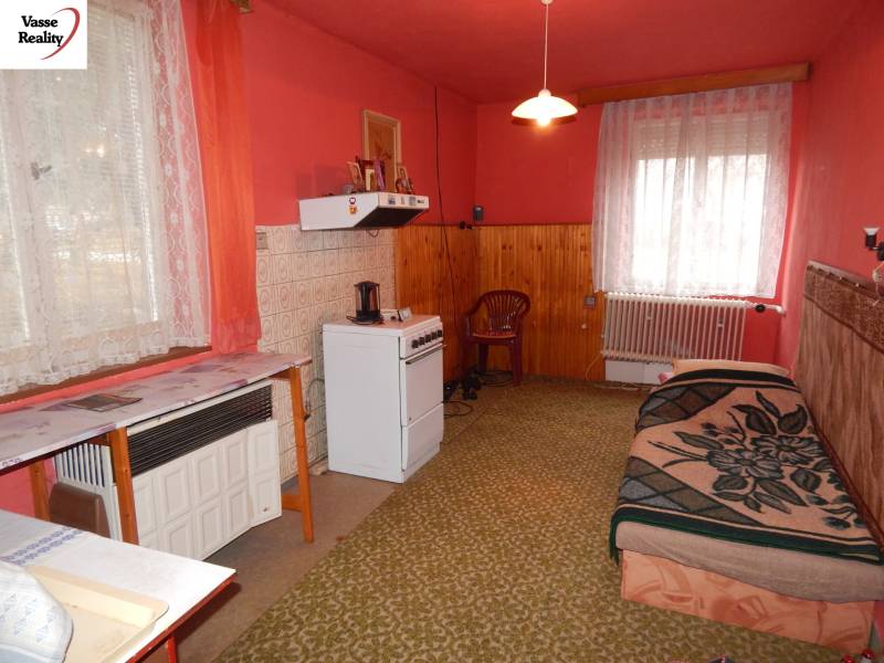 Interior of a family house with carpeted floor, pink walls, and a gas stove.