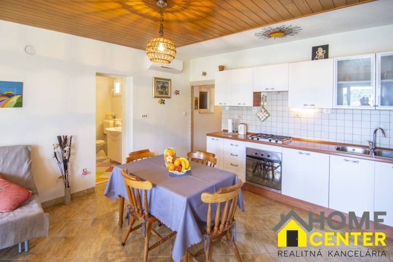 Kitchen in a recreational apartment with wood-decor flooring and a dining area.