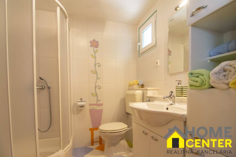 Bathroom in a recreational apartment with floral tiles and a white sink.