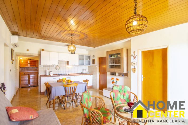 Recreational apartment with a kitchen, dining table, and wooden decor flooring.