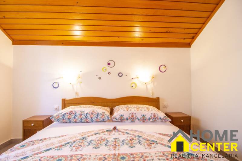 Bedroom in a Holiday Apartment with a bed and decorations on a white wall.