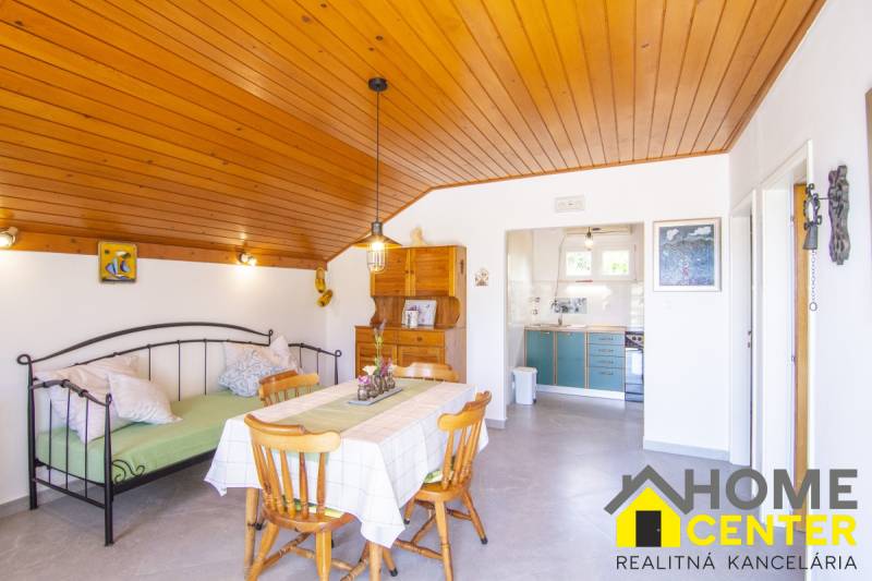 Recreational apartment with wood-decor flooring, dining table, and kitchen.