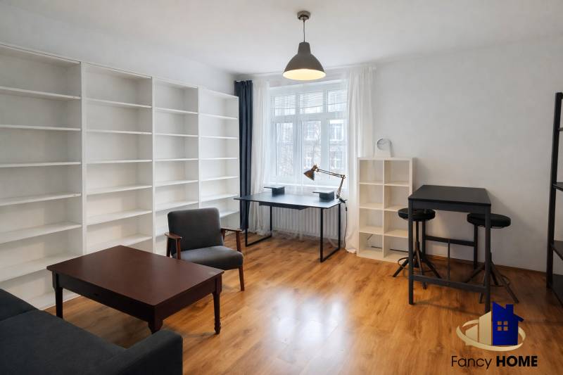 Interior of a 2-room apartment with a wooden decor floor, large shelves, and modern furniture.