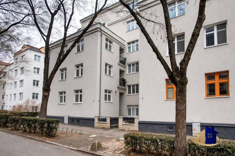 Apartment building in Bratislava at Jurajov Dvor, Pri starej prachárni. Four-story building, trees, sidewalk.