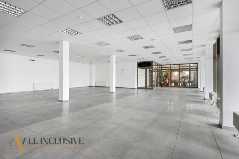 Spacious commercial spaces with tiles, large windows, and white walls.