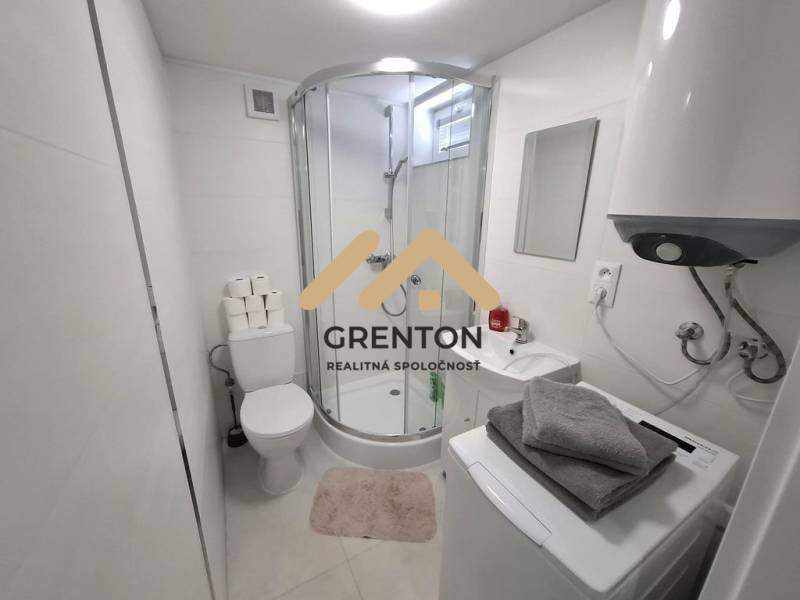 A bathroom with a bathtub, washing machine, boiler, and sink in a cottage. Minimalist design.