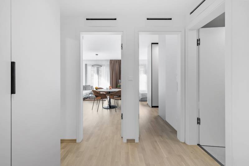 Interior of a 2-room apartment with a wooden decor floor, view of the living room and bedroom.