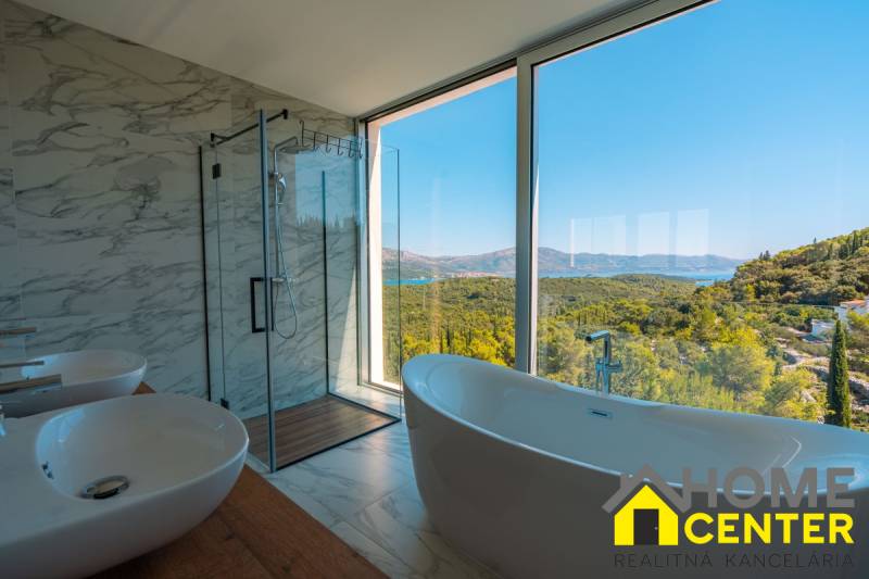 Luxury bathroom in a villa with a view of the sea and nature, floor with wooden decor.