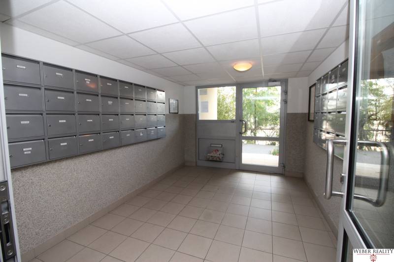 Lobby of an apartment building with mailboxes and glass doors.