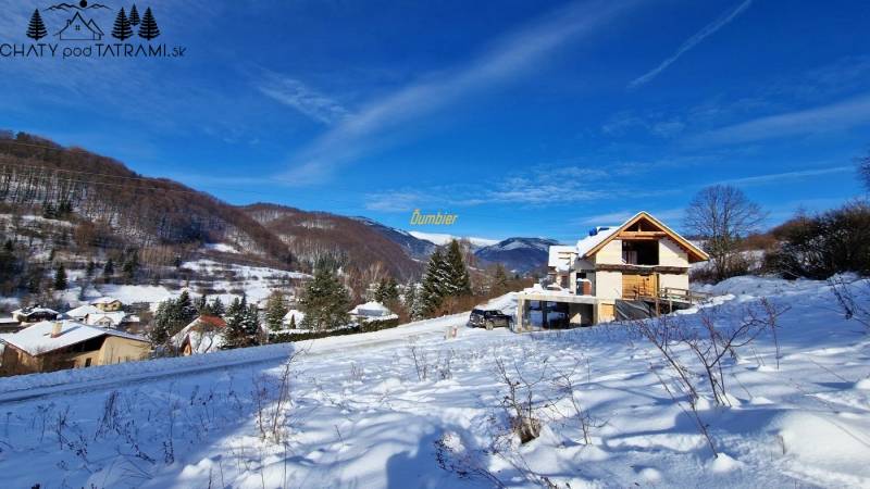 A snowy landscape in Mýto pod Ďumbierom with a view of the mountains and a building on the property.