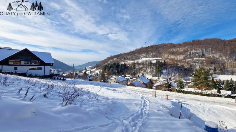 Snow-covered residential plots in Mýto pod Ďumbierom offer a winter panorama of the mountains.