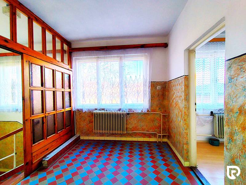 Interior of a family house with colorful tiles and wooden elements on the wall and doors.