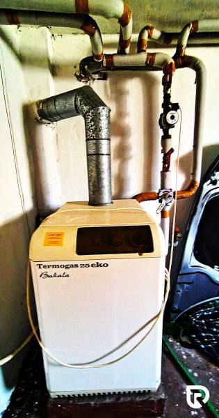 Gas boiler Termogas 25 eco with connected pipes in a family house.