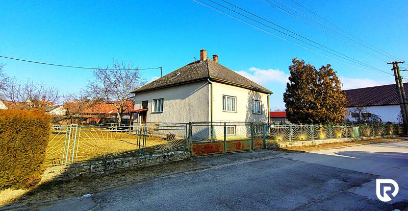 A family house on Sadová Street in Borský Mikuláš with a fenced garden and blue sky.