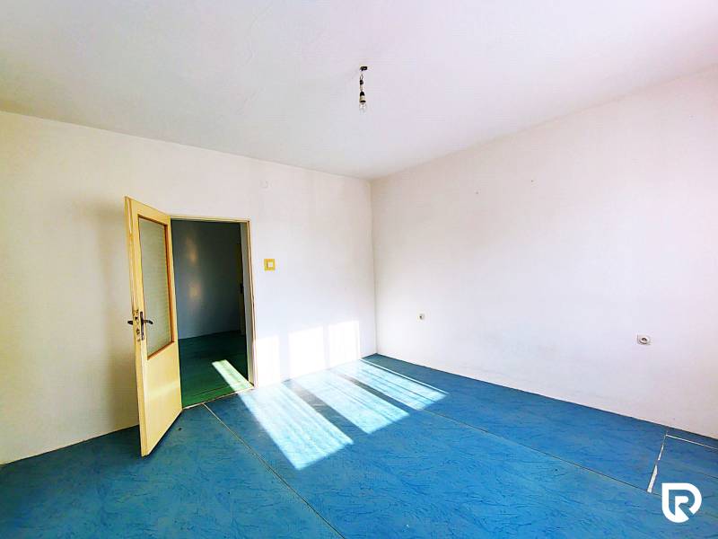 A room in a family house with a blue floor and open doors.