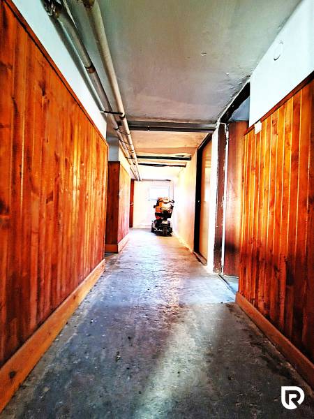 A hallway with wooden paneling and a motorcycle in a family house.