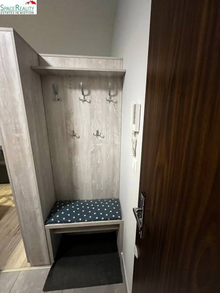 Entrance hall with coat racks and a bench in a 2-room apartment.