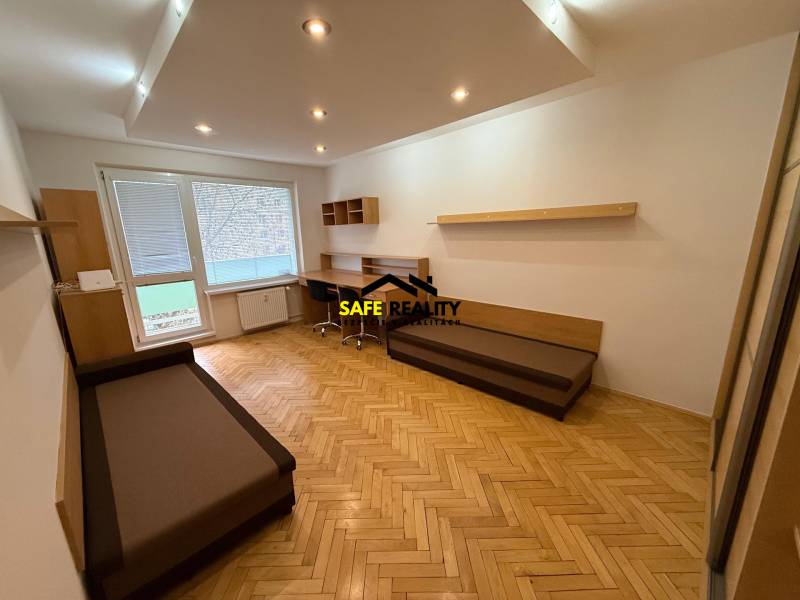 Living room in a three-room apartment with a wooden decor floor and a work desk.