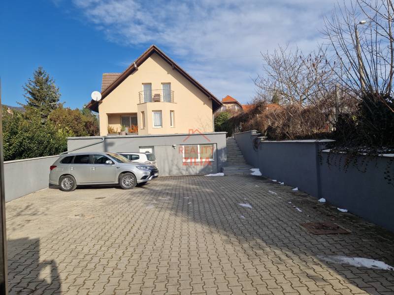 A parking lot with two cars in front of a family house on Jelenecká Street in Nitra.