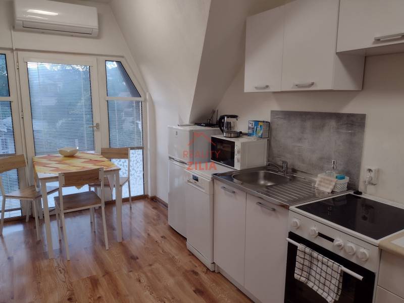 A kitchen in a family house with a wooden decor floor and a dining table.