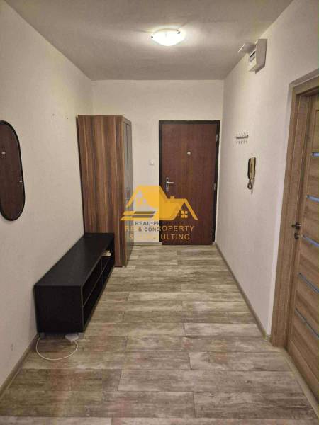 Cozy entrance hall in a 3-room apartment with a wood-patterned floor and a cabinet.