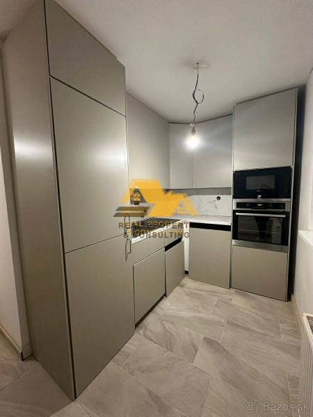 A kitchen in a 2-room apartment with modern cabinets and appliances.