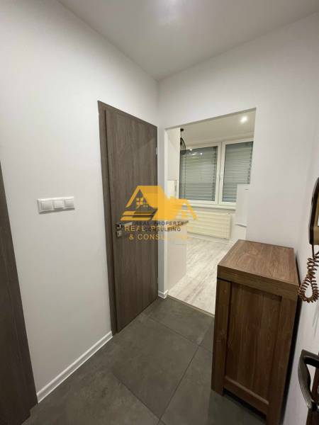 Interior of a 1-room apartment with tiles and flooring with a wood decor.