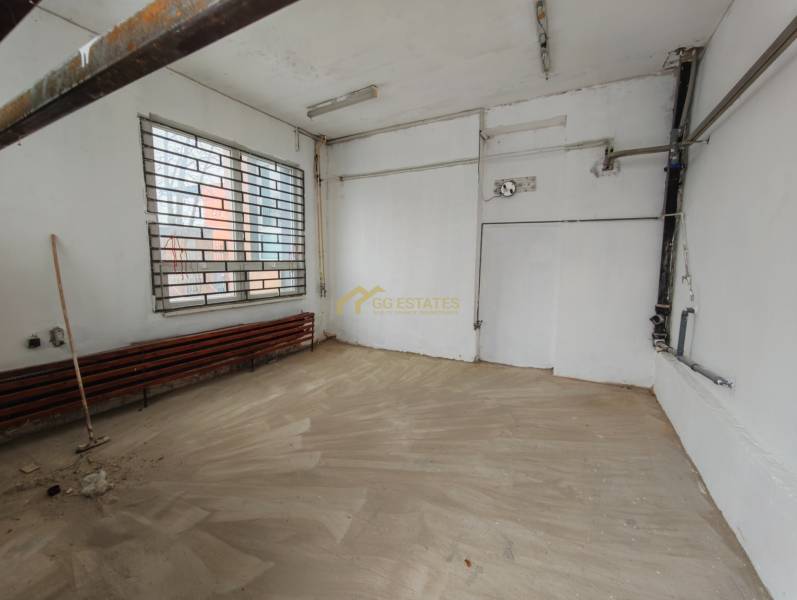 Interior of garages with a window and a grille, floor with wooden decor.