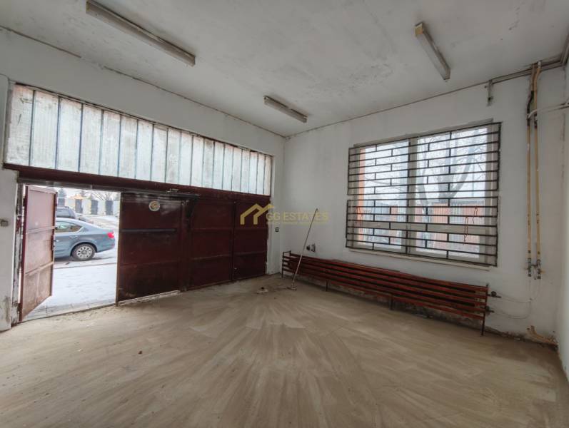 Interior of a garage with a wooden decor floor and a metal gate.