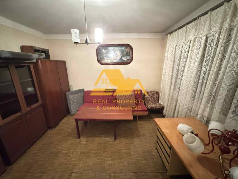 A room in a family house with furniture, curtains, and a wooden decor floor.