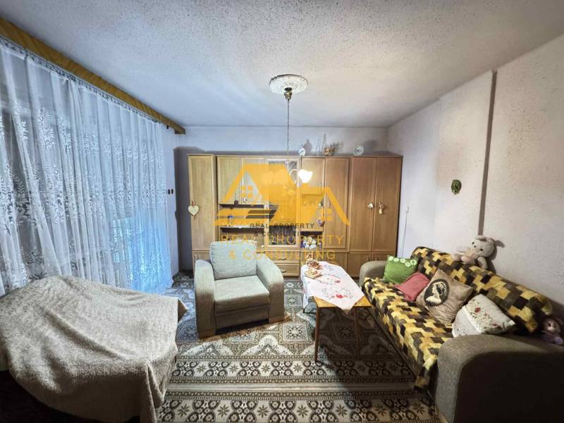 Living room in a family house with a sofa, carpet, and cabinets with decorations.