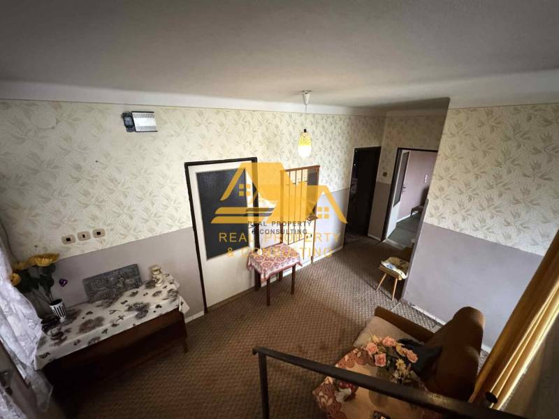 Interior of a family house with patterned wallpaper, furniture, and floral decoration.