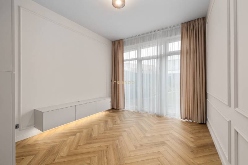 Living room in a two-room apartment with a wooden decor floor and white furniture.