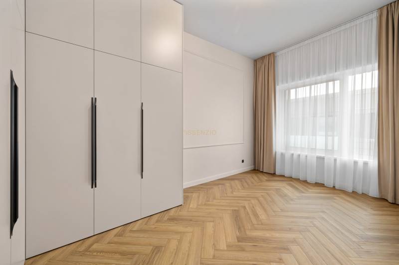 Interior of a 2-room apartment with a wooden decor floor and a large wardrobe.