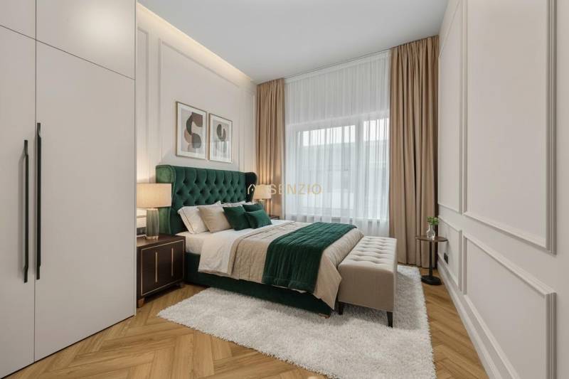 Bedroom with a bed, nightstands, pictures on the wall, and a floor with a wooden decor.