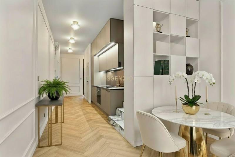 Interior of a 2-room apartment with a kitchen, dining table, and floor with wooden decor.