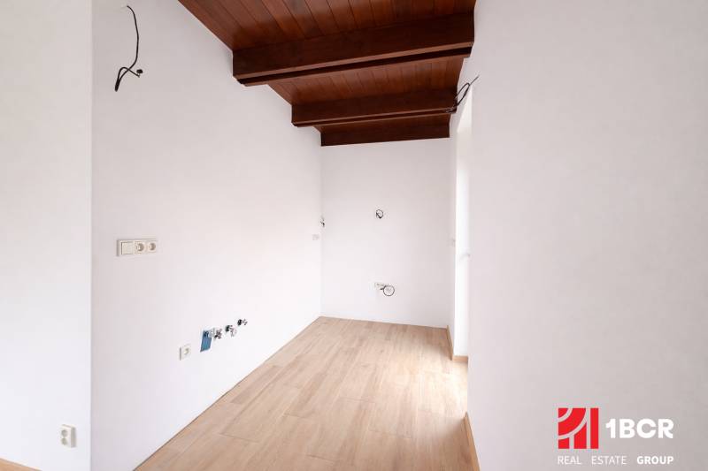 Interior of a family house with a wooden decor floor and a wooden beam ceiling.