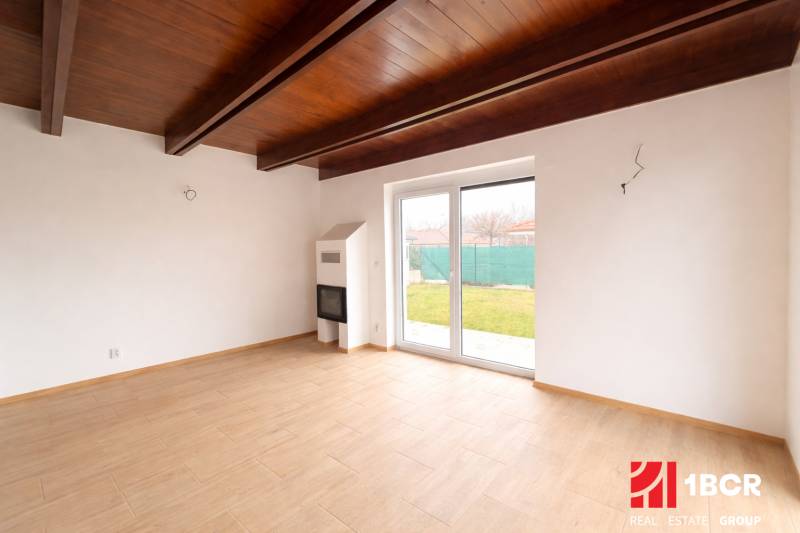 Interior of a family house with a wooden decor floor and large windows to the garden.