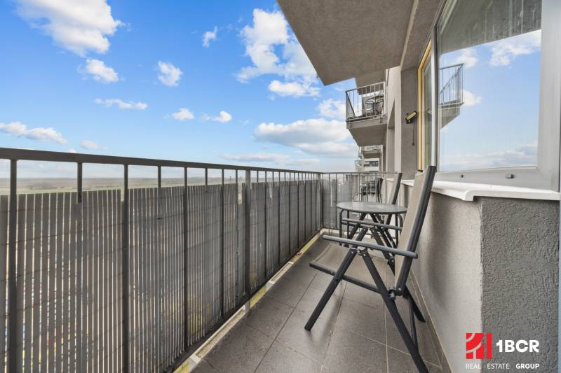 The balcony of a 2-room apartment on Budatinska Street in Bratislava-Petržalka, with a view of the countryside.