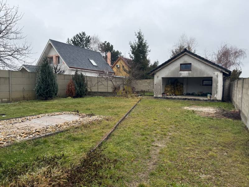 The garden of a family house on Pri prvej kaplnke Street in Záhorská Ves with a garage.