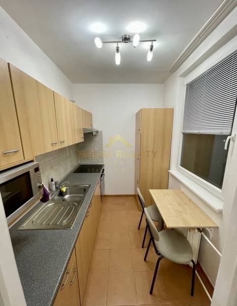 A kitchen in a studio apartment with a minimalist table and light furniture.